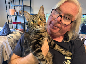 man holding a beautiful tabby cat