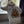 person looking out of window wearing a white hoodie with a tattoo style design of a woman with lots of cats