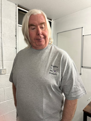 Person wearing a gray sweatshirt with text and graphics, standing indoors.