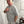Person wearing a gray sweatshirt with text  saying fragility is my strength whilst standing in a studio