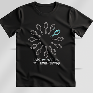 Black t-shirt with a graphic design and text saying living my best life with limited spoons on a gray background
