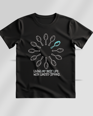 Black t-shirt with a graphic design and text saying living my best life with limited spoons on a gray background