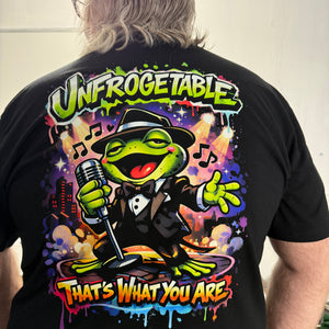 Person wearing a black t-shirt with a colorful cartoon frog graphic design and text.