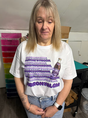 Person wearing a white t-shirt with purple text and graphics concerning fibromyalgia, standing indoors.