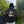 Person wearing a black hoodie with bible text against a natural background