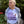 Person wearing a white t-shirt with text and a bottle graphic, standing outdoors with greenery in the background.
