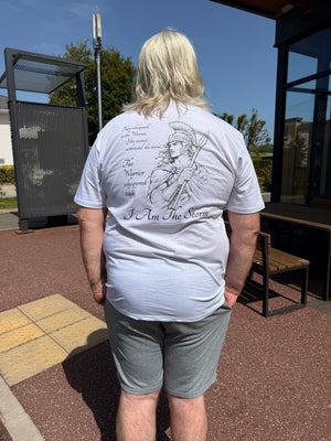 Person wearing a white t-shirt with text and graphics outdoors on a clear day.