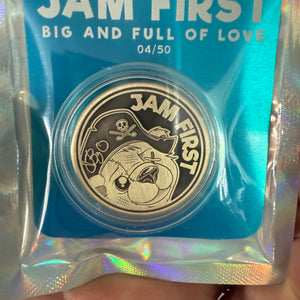 golf ball marker with 'Jam First' branding in a blue packaging sleeve.