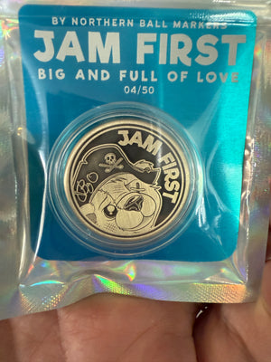 golf ball marker with 'Jam First' branding in a blue packaging sleeve.