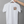 White t-shirt with a graphic design on a hanger against a gray background