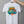 White t-shirt with 'Stay Pawsitive' design on a hanger against a gray background